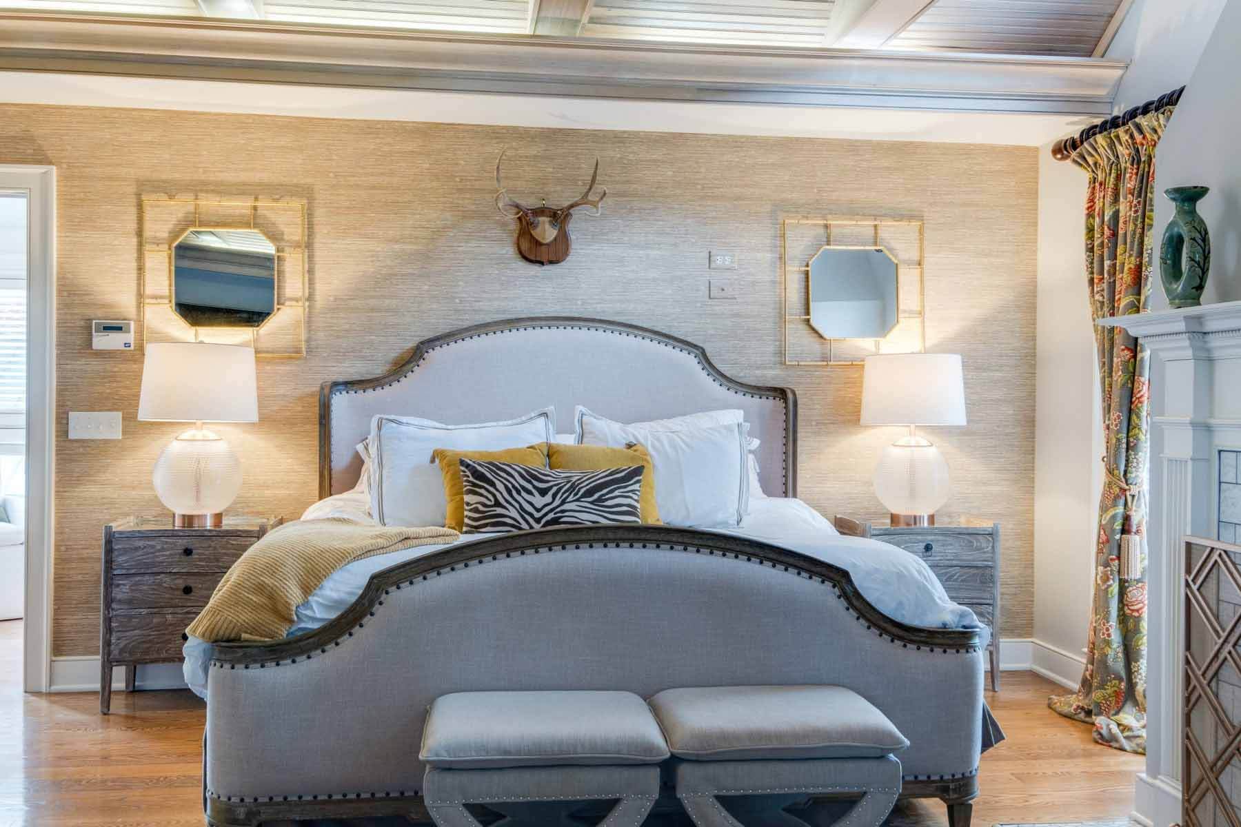 "I wanted something super traditional," Therese says of the master bedroom decor. "We went with a basic grasscloth wallcovering from Wallpaper and Designer Home Consignments. It's a very traditional French bed with matching end tables because I wanted something that felt hotel-esque, comfortable and clean — not as funky as the rest of the house." Image: Zach Harrison Photography Master bedroom at the Shute-Turner House, with grasscloth walls