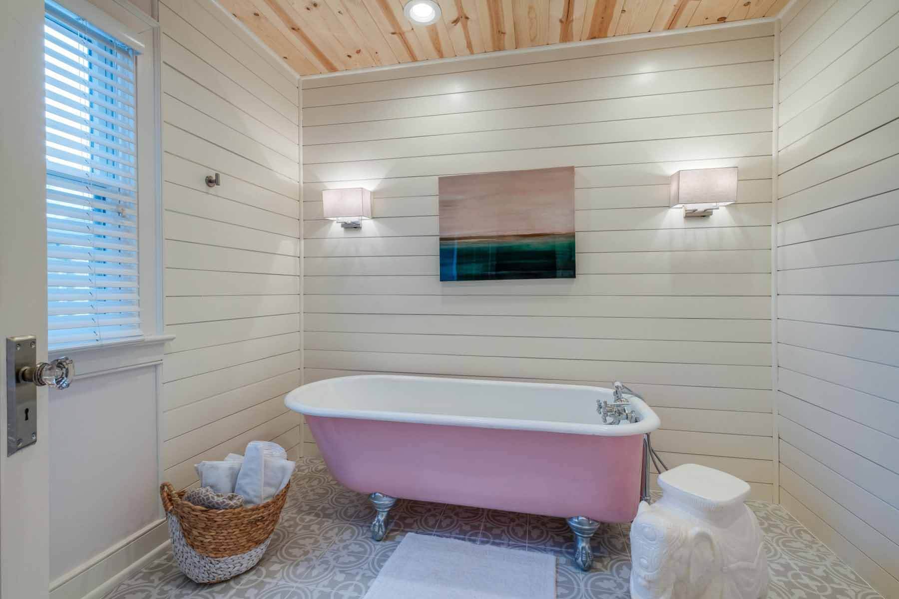 "When my parents visit, I wanted to have a sanctuary for my mom where she can relax," says Therese. Before the renovation, the room possessed a plastic alcove tub and shower. In its place, Therese added a six-foot, claw-foot tub she found at Preservation Station. The result is an oasis with a feminine touch that her mom can thoroughly enjoy. Image: Zach Harrison Photography Bathroom with pink tub