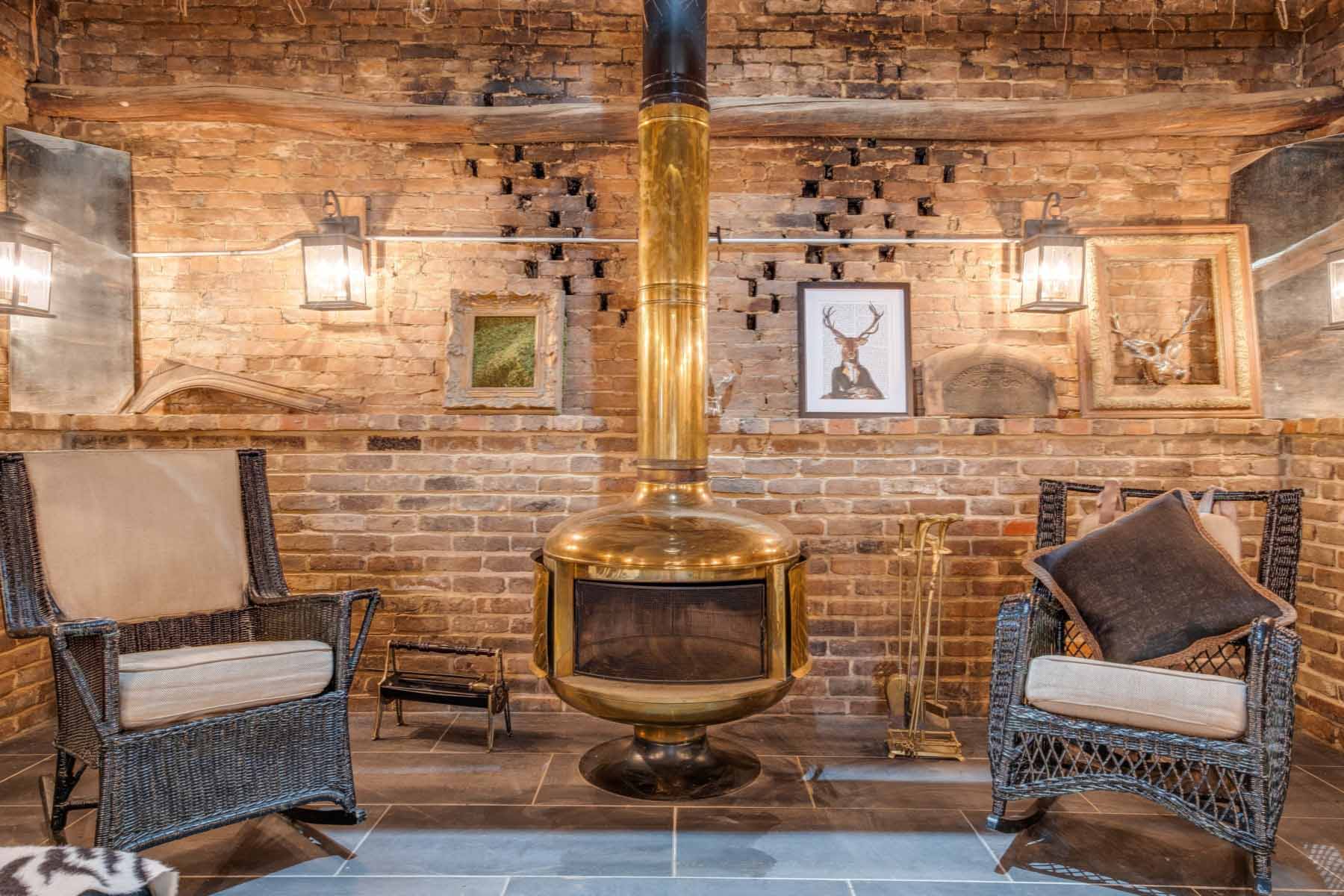 A long ledge that runs the length of the smokehouse holds artifacts that were uncovered on the property during the renovation. Image: Zach Harrison Photography The smokehouse fireplace with seating area