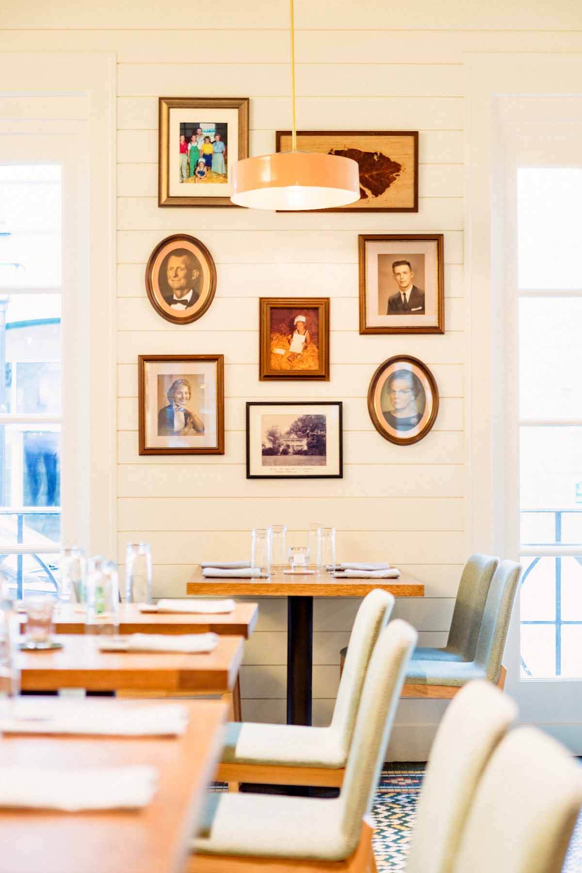 Family photos look down at diners to add a homey feel to Lenoir. Image: Baxter Miller Family pictures hanging on the wall in Lenoir