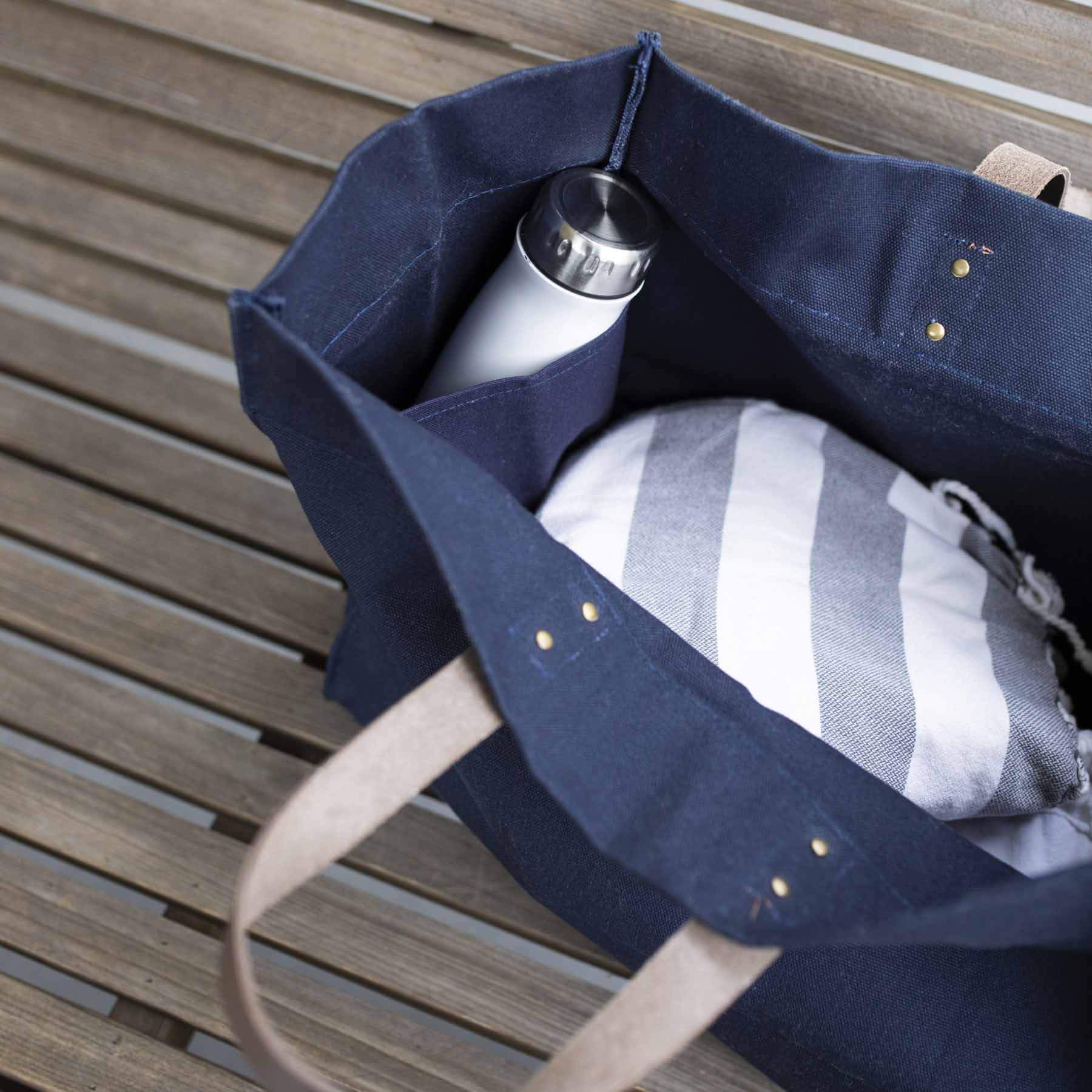 Look inside blue tote with water bottle and blanket