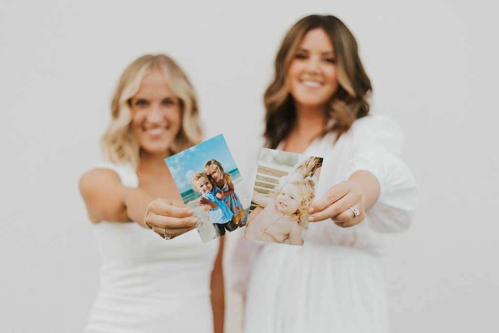Thanks to successful fertility treatments, Mollie and Lauren have several beautiful children between them. Mollie and Lauren hold photos of their children