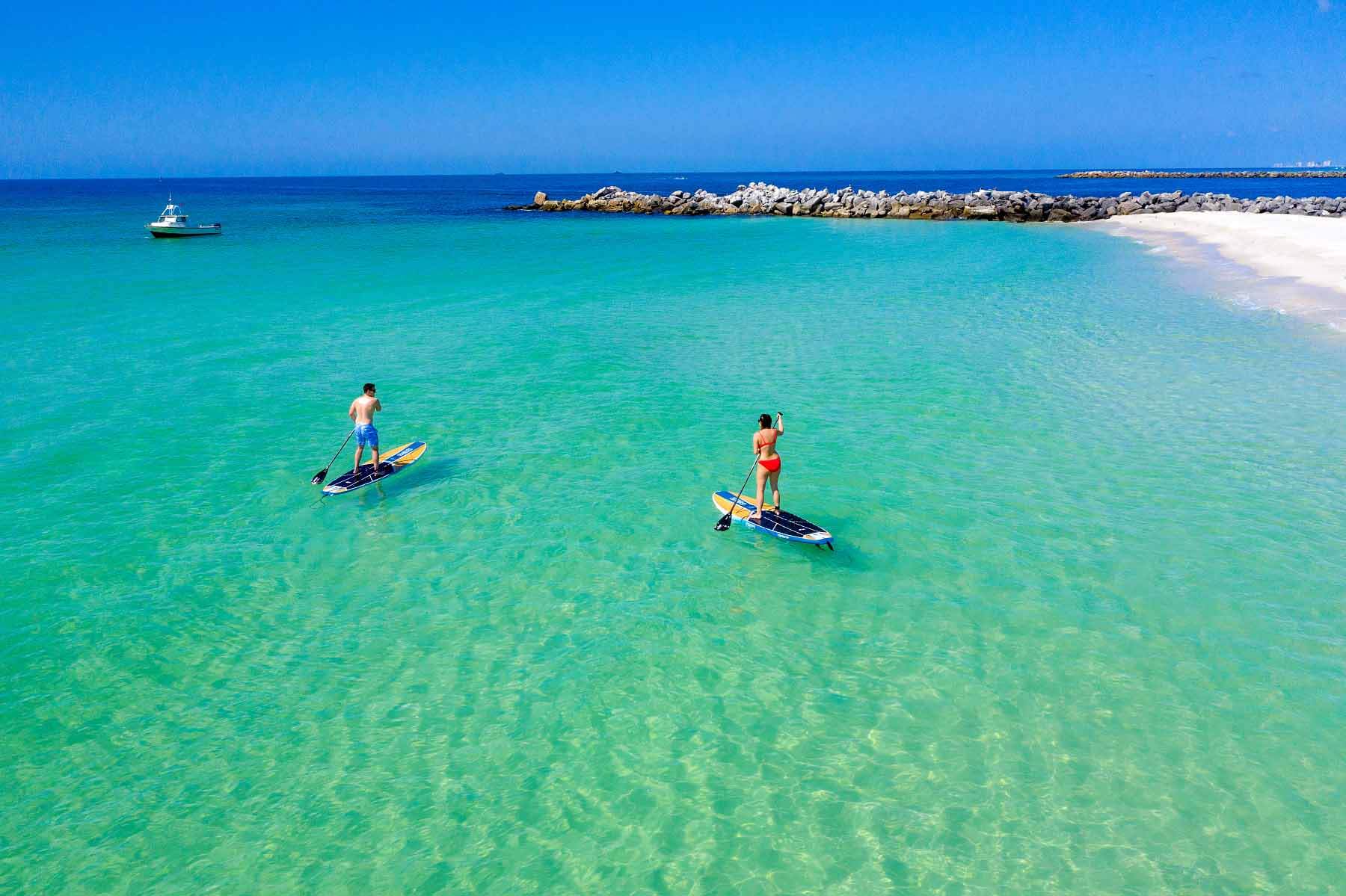 Two people paddleboarding in ocean