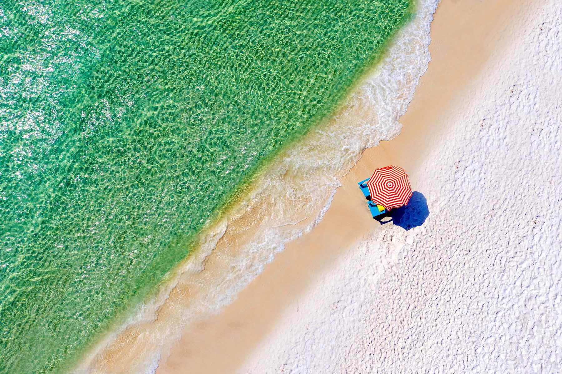 Aerial view of red striped umbrella on beach