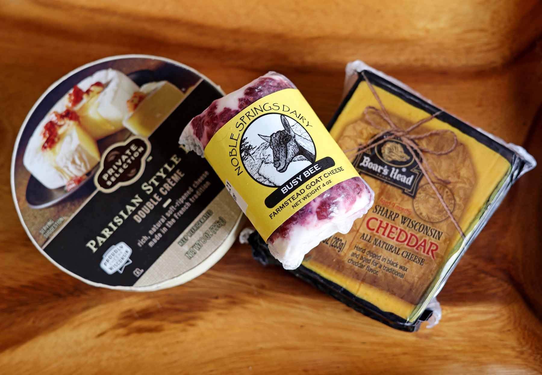Boar’s Head Sharp Wisconsin Cheddar Cheese, Private Selection Parisian-Style Double Creme Brie, and Noble Springs Dairy Goat Cheese from Kroger