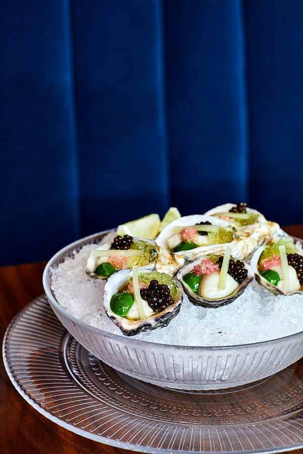 Oysters with caviar and bottarga, sitting in a bowl of ice at The Continental