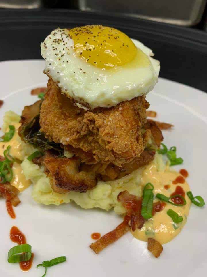 Everything's better with a fried egg on top, including this Southern Man's Stack made with fried chicken and pork belly. Brunch from Grille on Main, a new Southern restaurant
