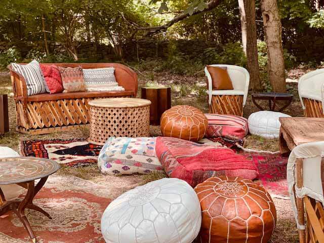 Outdoor lounge area with leather ottomans, rugs and couches