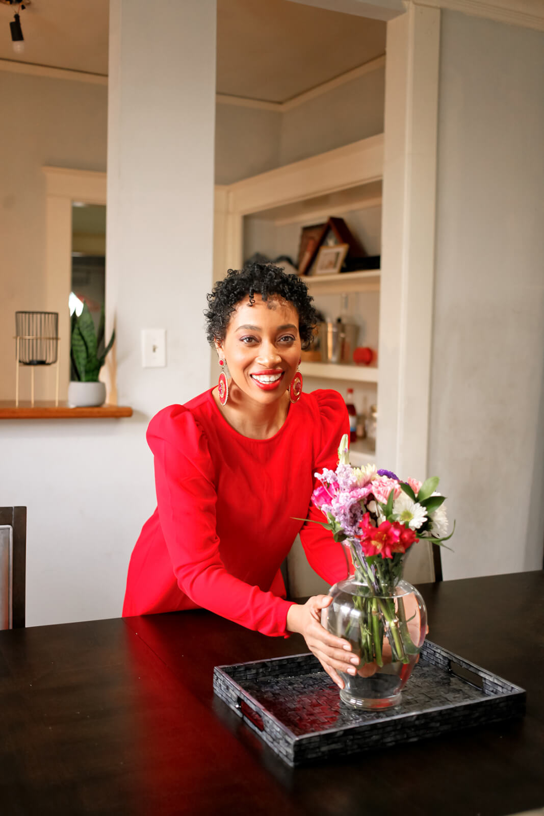 Andrea Fenise posing with flowers in Big Mama's house