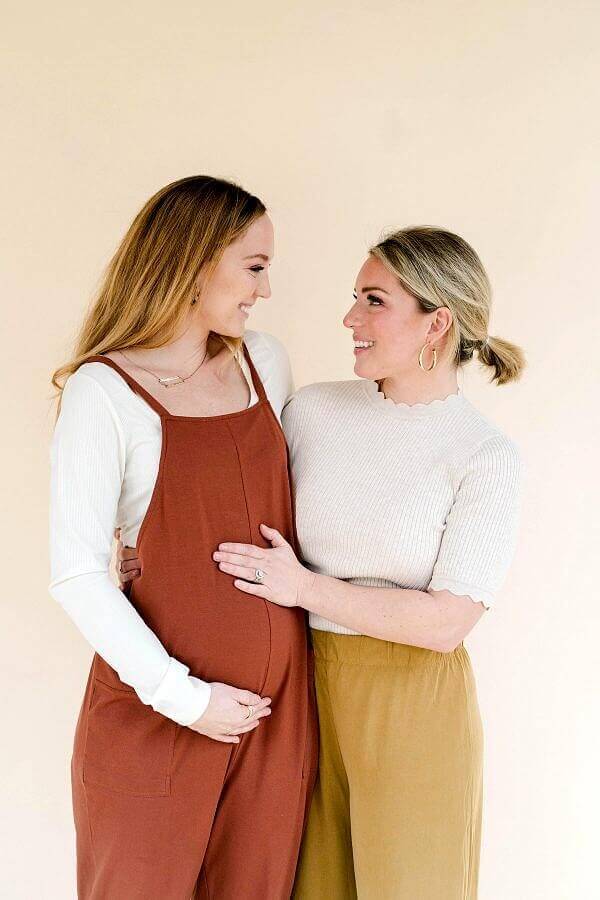 "Sarah and Richard treated us to a babymoon," says Cathey. "We went to an all-inclusive resort in Cancun. It was just the four of us, so we really got to soak up this season. It was a magical time." Image: Katelyn Brown Cathey and Sarah, smiling at each other and holding Cathey 's baby bump