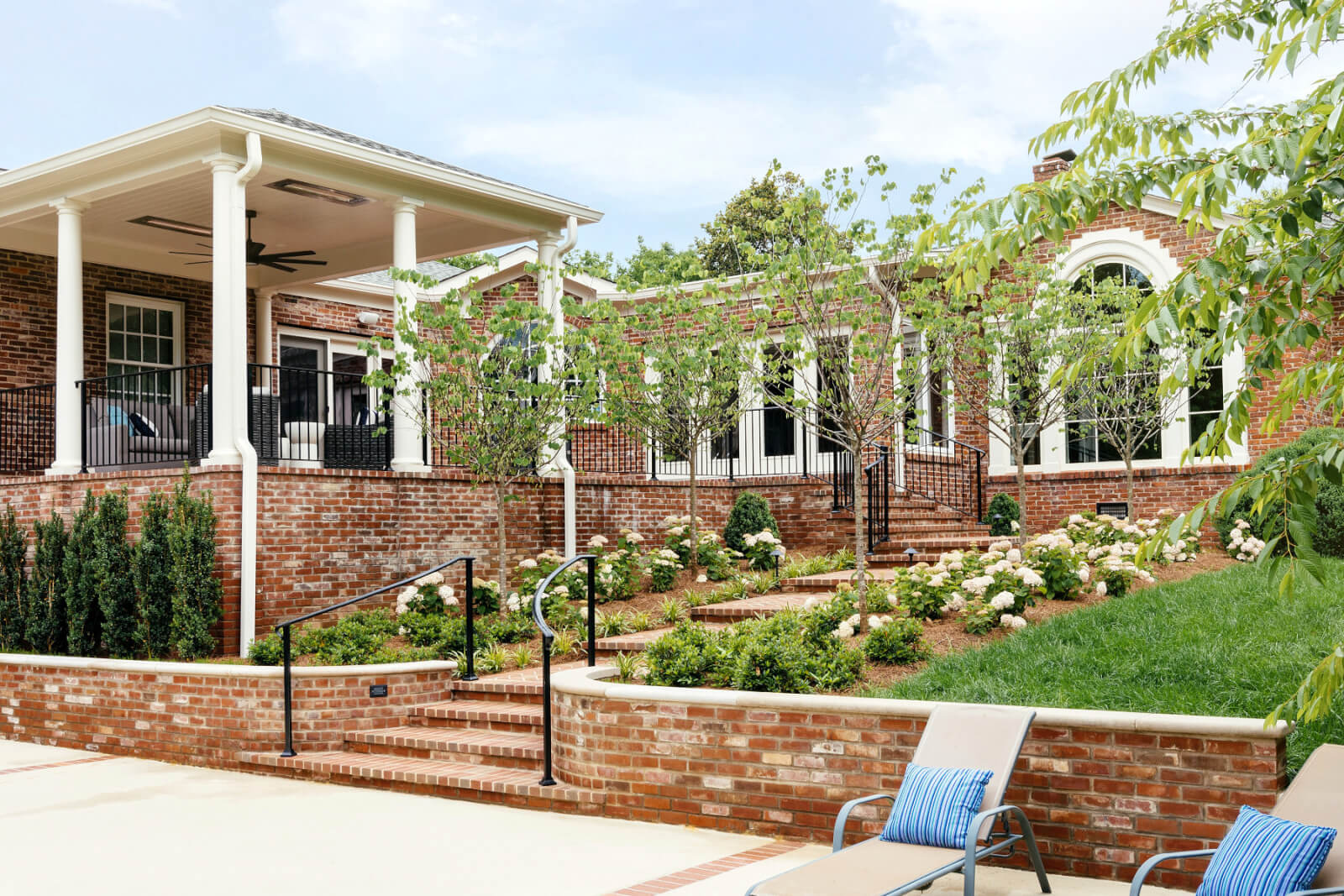 Stone terrace and covered porch on a renovated '90s home