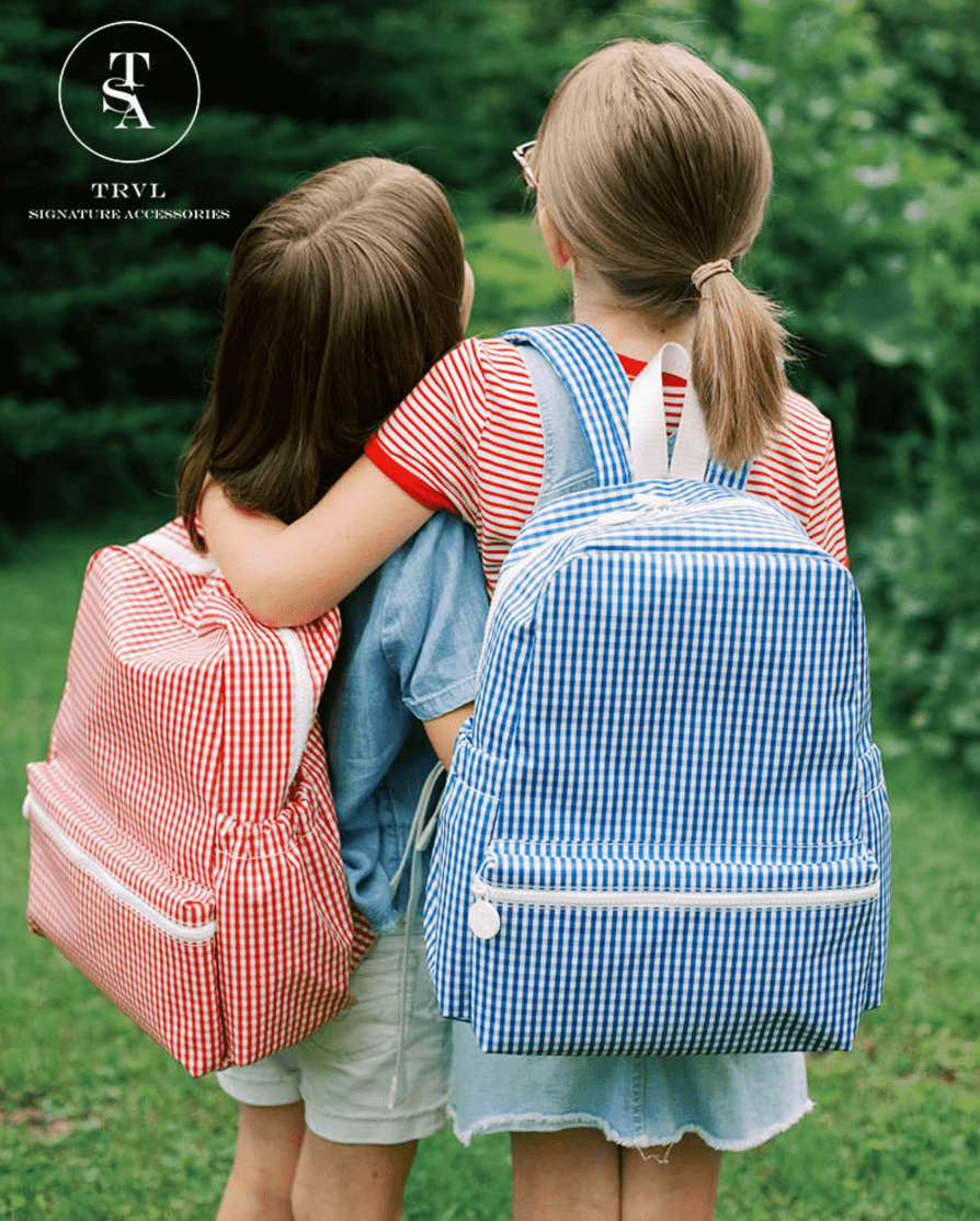 Two young girls modeling plaid backpacks