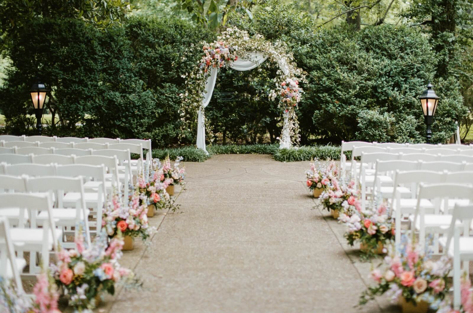 The flower-lined path leading up to a wedding ceremony arch at Riverwood Mansion.