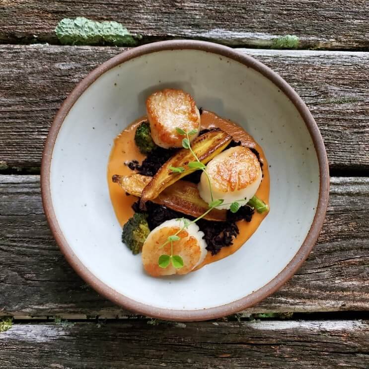 A scallop dish in a ceramic bowl