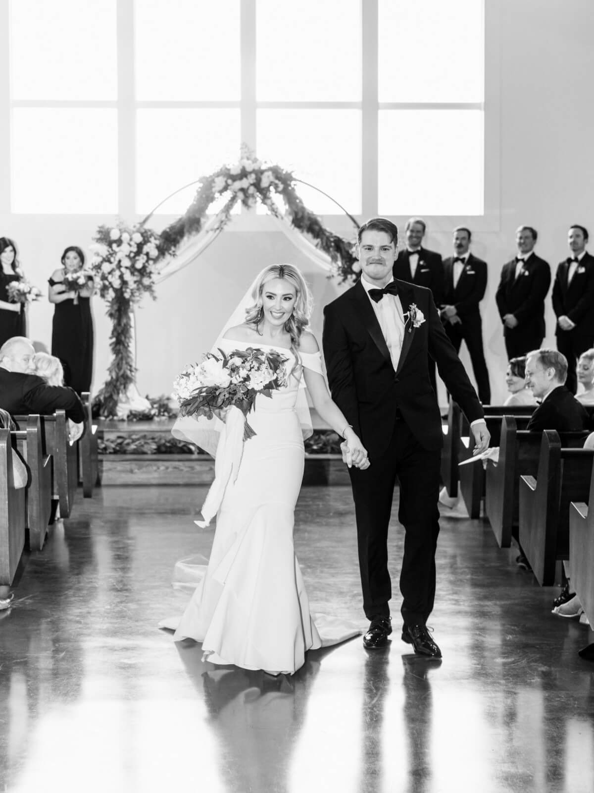 The bride and groom walk back down the aisle after exchanging vows.