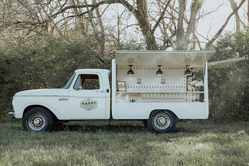 The Happy Campers white pick-up truck with a mobile bar.