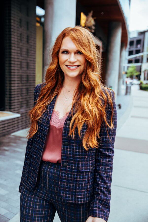 AJ in a plaid suit with a pink blouse. 