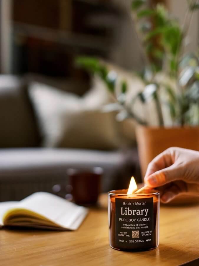 person lighting a library candle