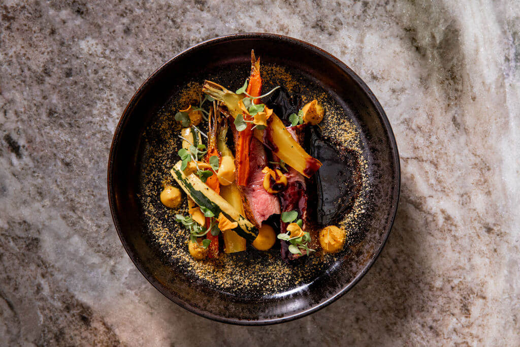 Vibrant and delicious, the dishes at Stationary are as beautiful as the setting in which they're served. Image: The Union Station Nashville Yards Colorful dish of carrots and steak