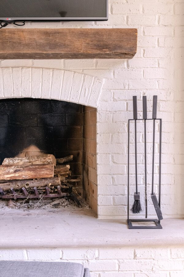 Close-up view of a porch fireplace with an exposed-beam mantel.