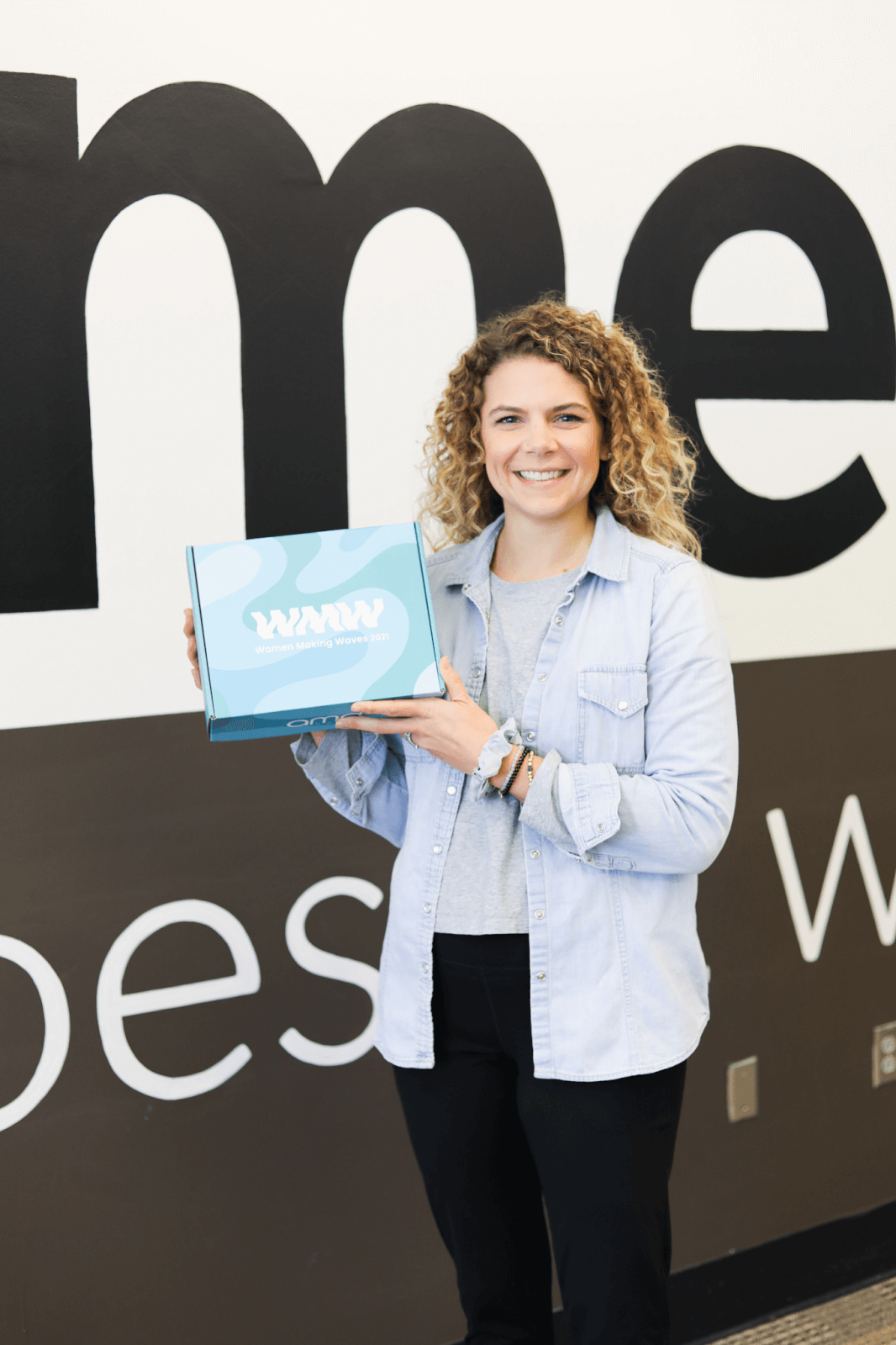 Lindsey holding "Women Making Waves" award from AMD Creative in 2021