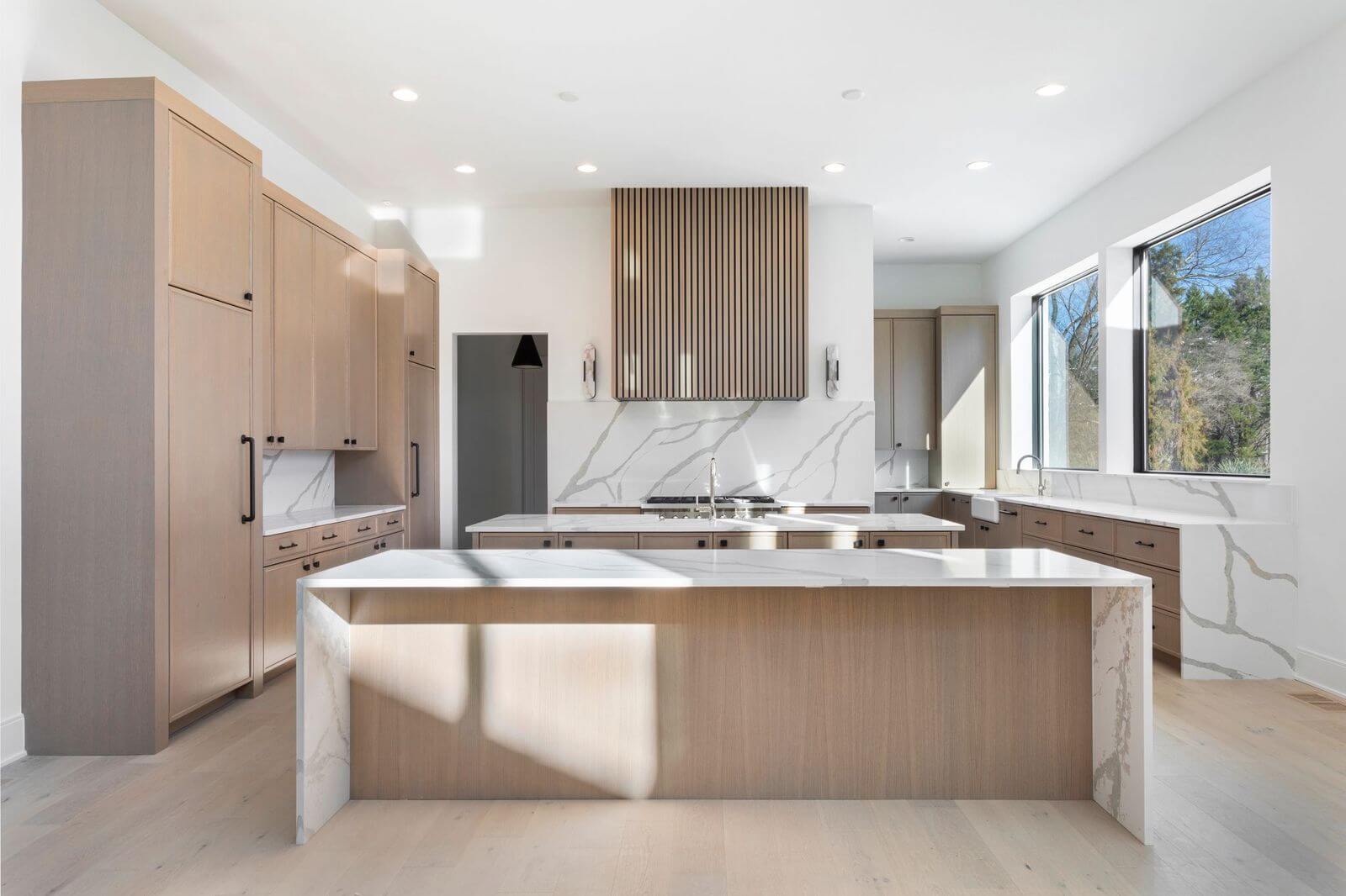 With kitchen with marble countertops and tan cabinetry
