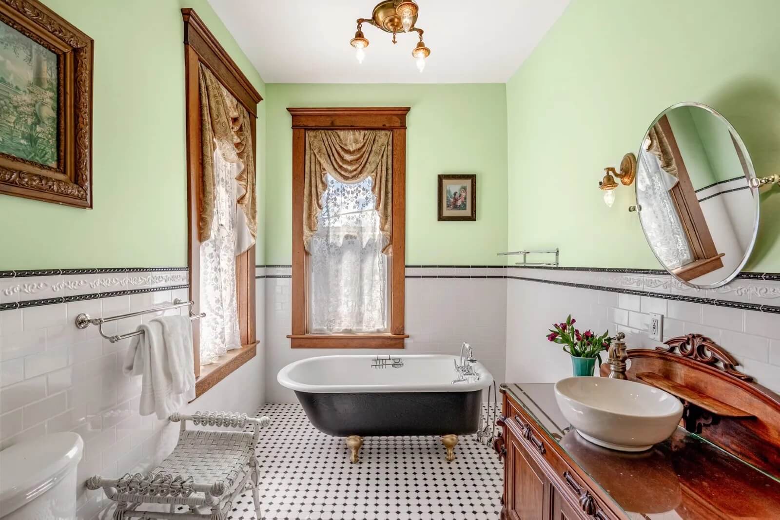 Full bathroom with black and white tile flooring at clawfoot tub at 205 South Military Avenue