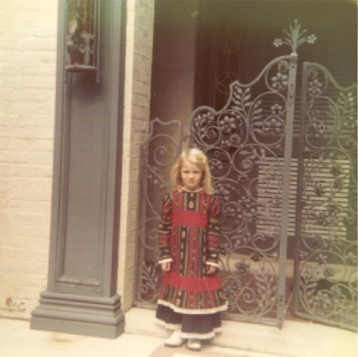 A young Delphine Sloane, in front of the gates