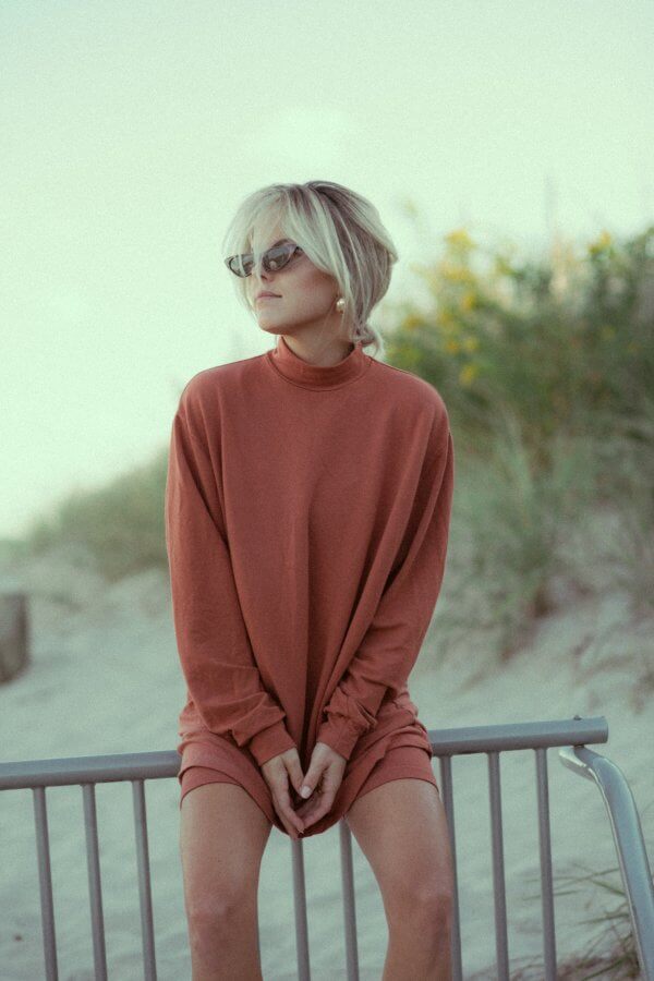 Christina Currey on a fence by the beach