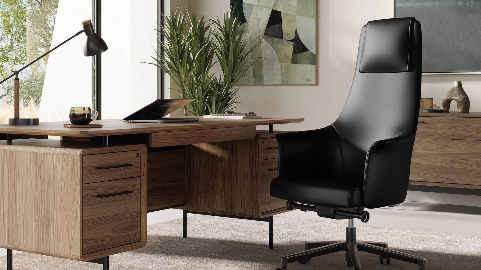 Modern office space with a Scandinavian design featuring a wooden desk, laptop, table lamp, and black leather chair. A plant and abstract art grace the background, offering a minimalist yet cozy ambiance.
