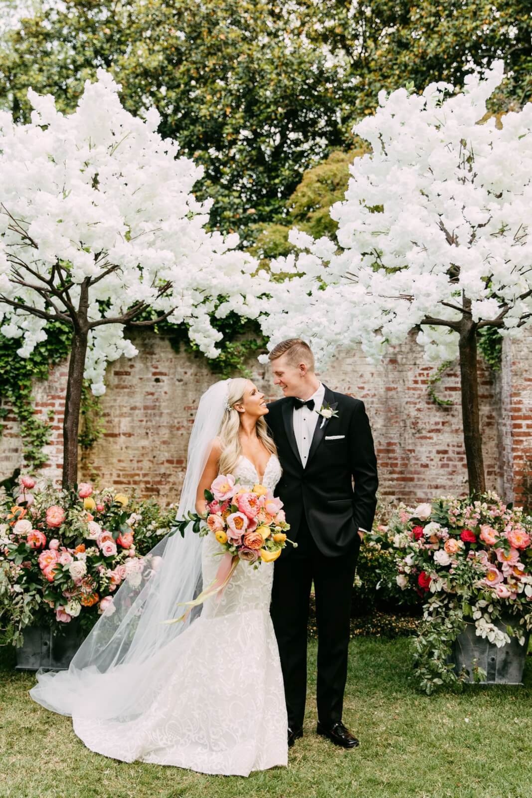 Bride and groom posing in front of elegant white trees