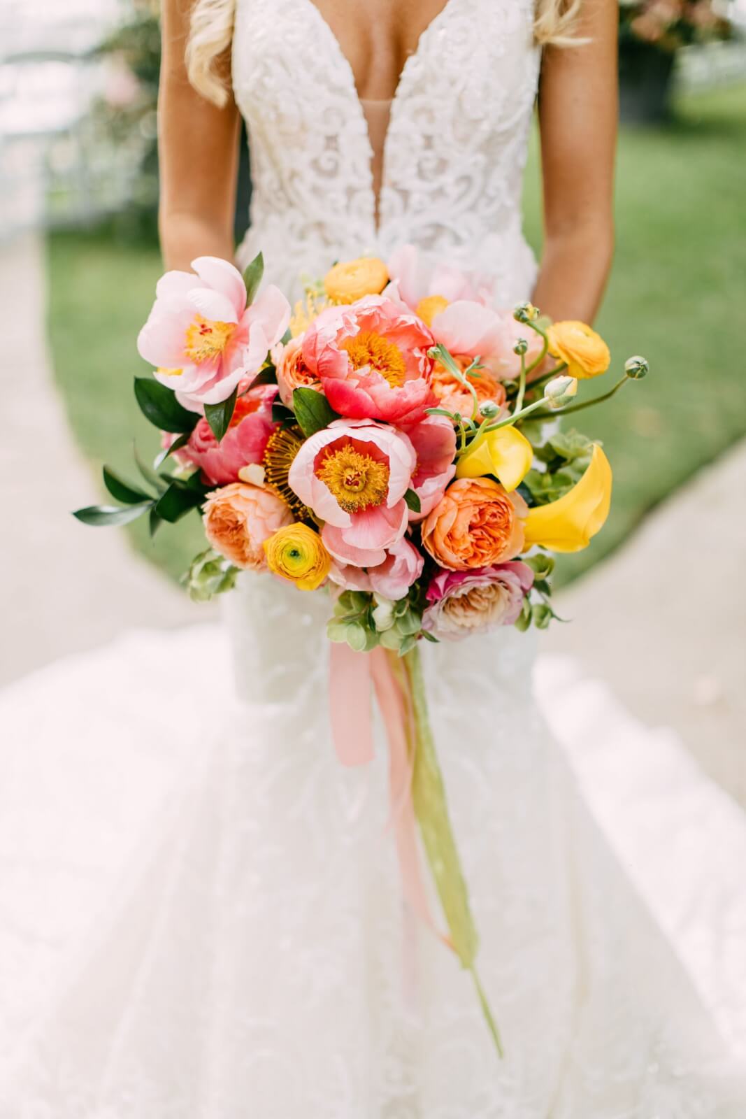 Close-up view of bride's bouquet with pink, orange, and yellow flowers