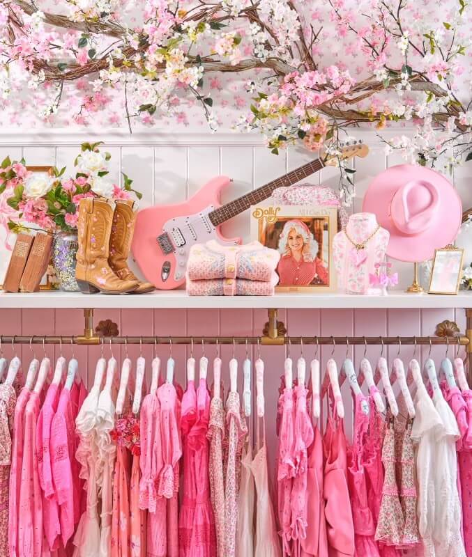 Interior of LoveShackFancy in 12South, featuring cowboy boots and lots of pink clothing.