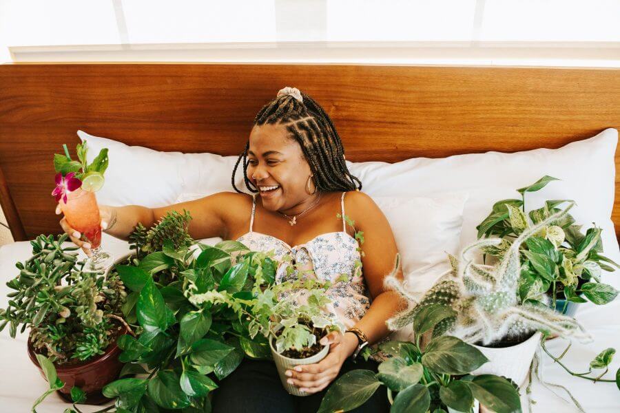 A woman surrounded by plants at the Elwood Hotel in Lexington KY