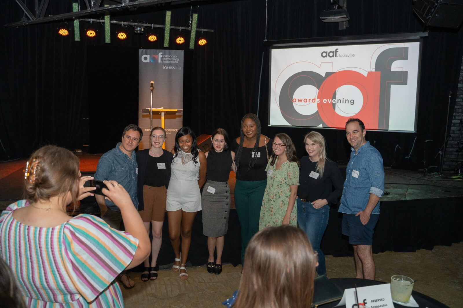 Ember Marr posing with a group of people at the AAF Awards
