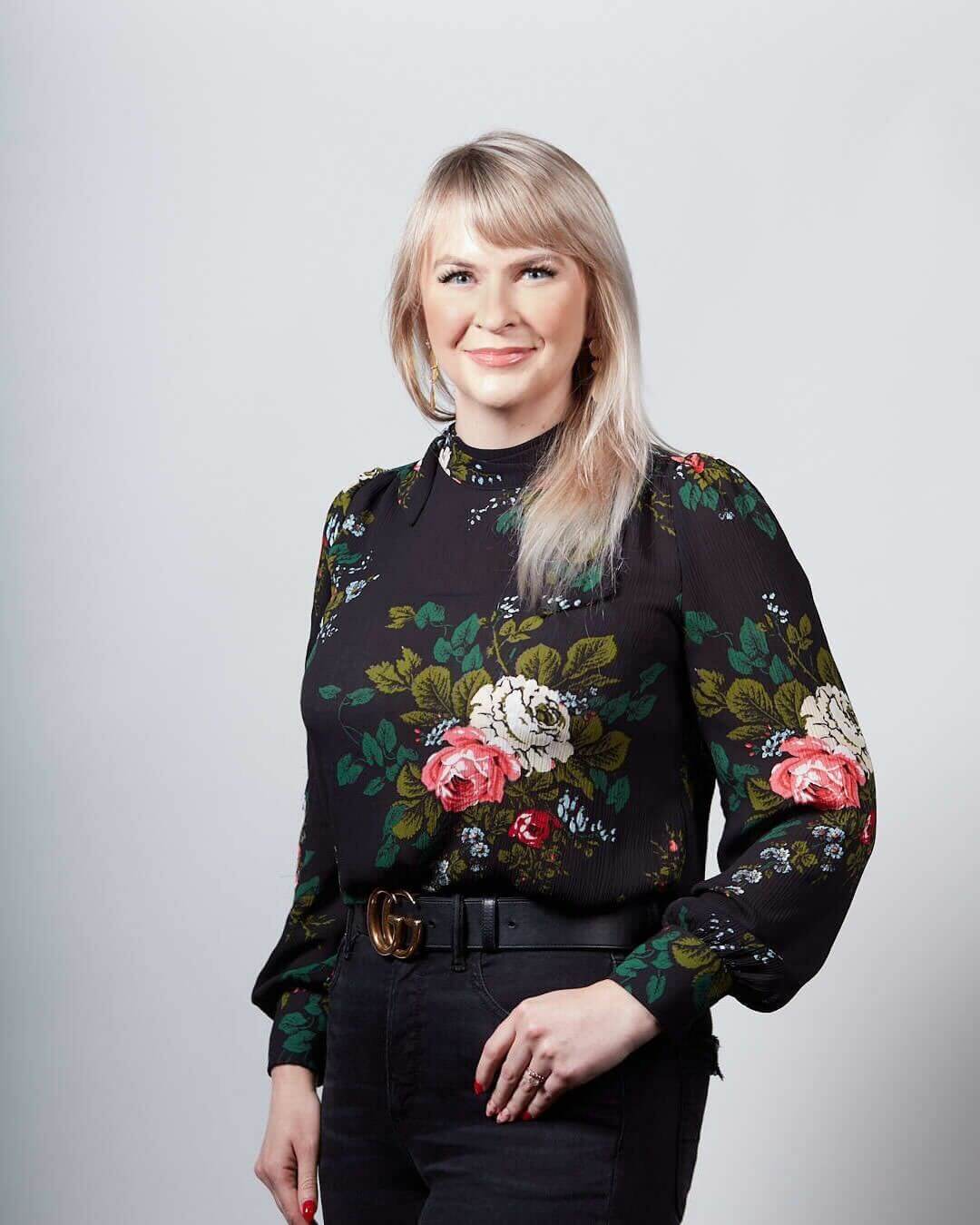 Ember Marr, president of LEAP Spark, posing in a black floral blouse