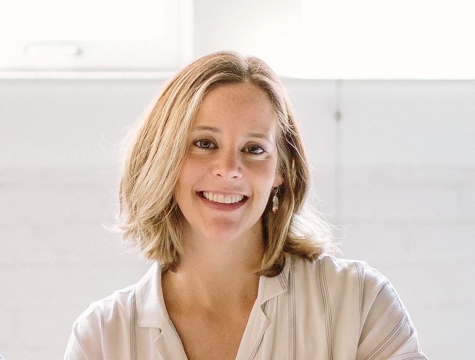 Dana posing in white blouse against a white background