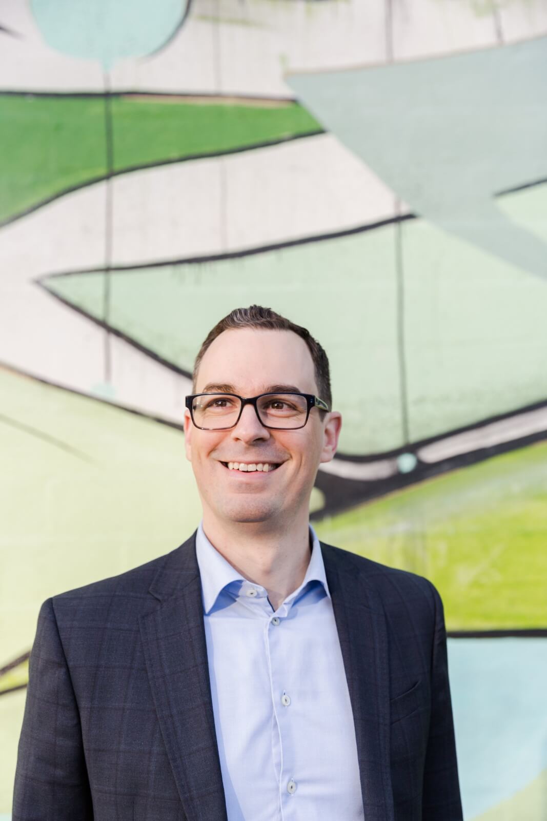 Aaron Dorn posing in front of a colorful mural