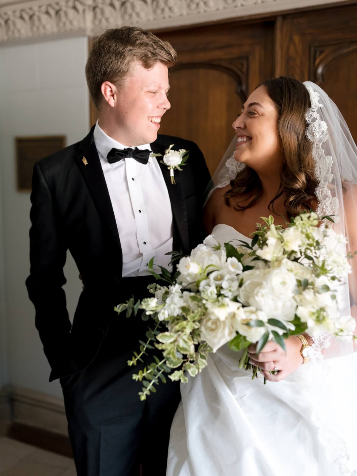 Maggie and Kevin smile at each other on their wedding day.