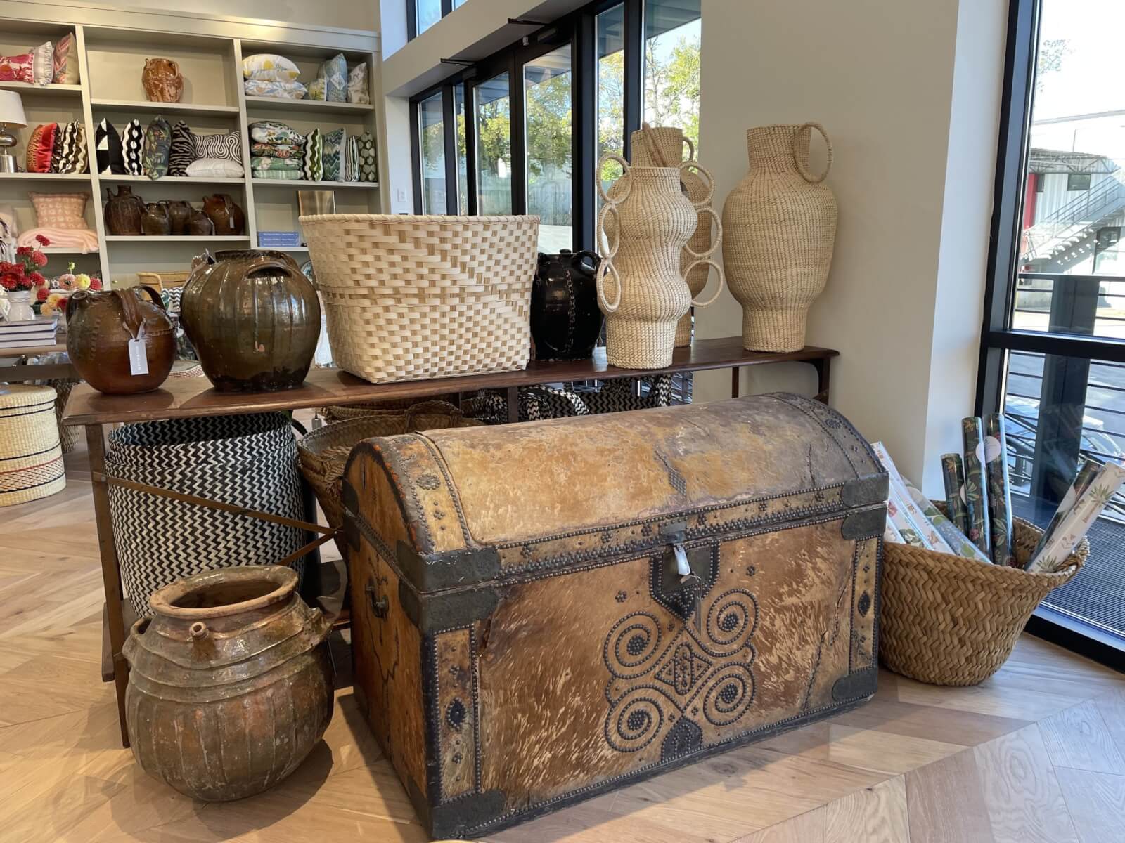 A giant trunk is surrounded by handwoven baskets and pottery.