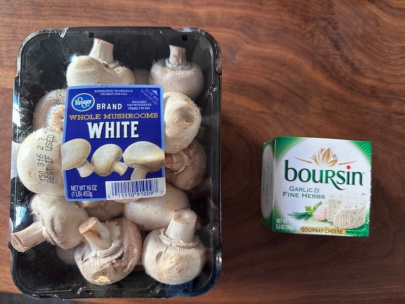 Whole white mushrooms in the package with a package of Boursin cheese.