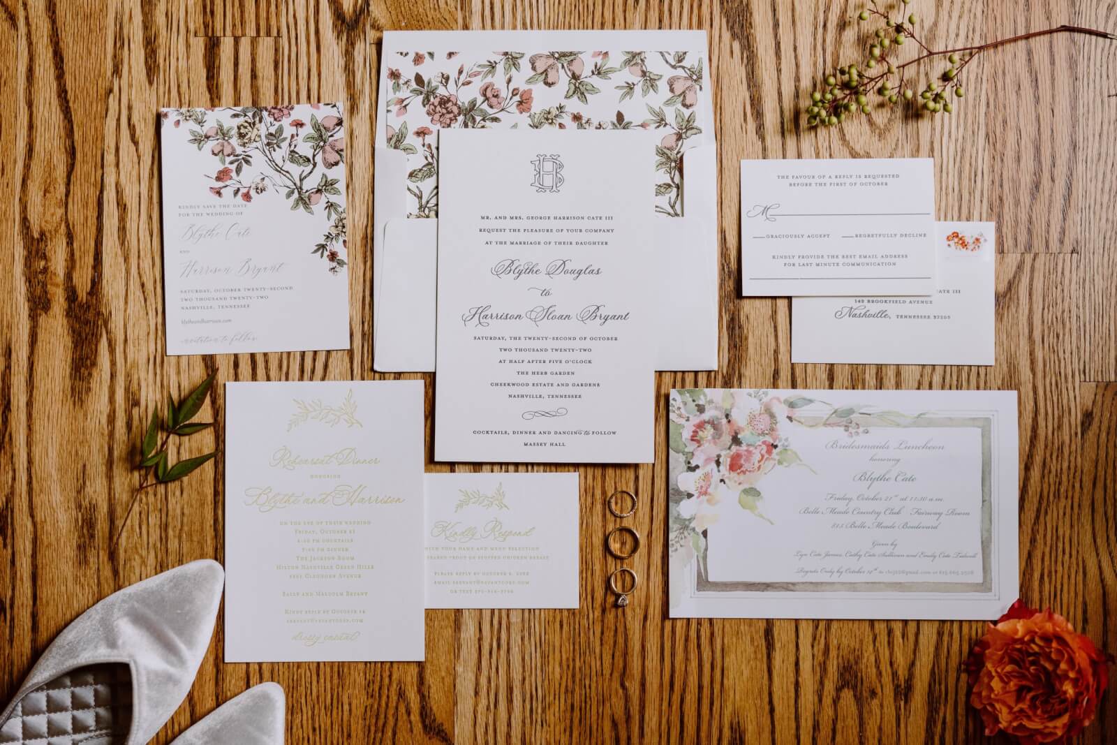 Invitation suite with floral touches on a wood background.