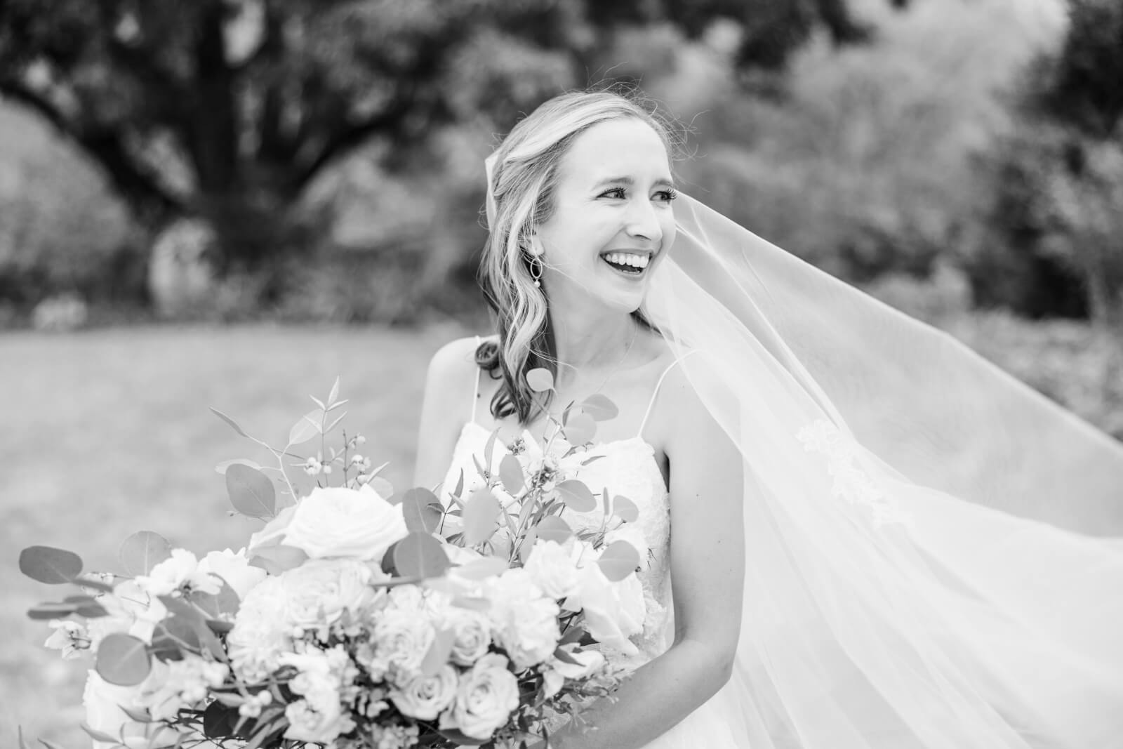 A black-and-white image of the bride, laughing.
