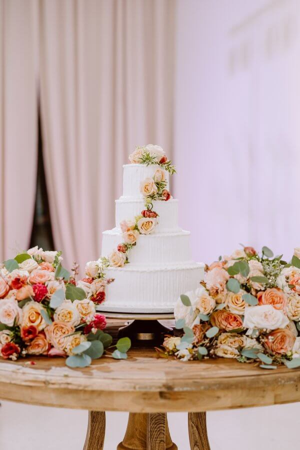 A four-tiered wedding cake with fresh florals.