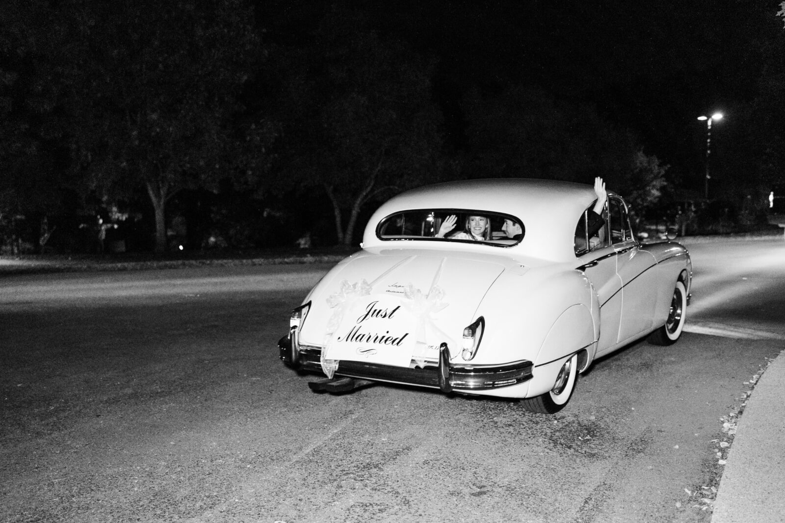 A Jaguar with a "Just Married" sign whisks the bride and groom away.