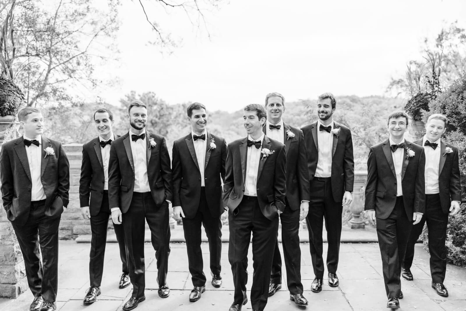 The groom walks with his groomsmen.
