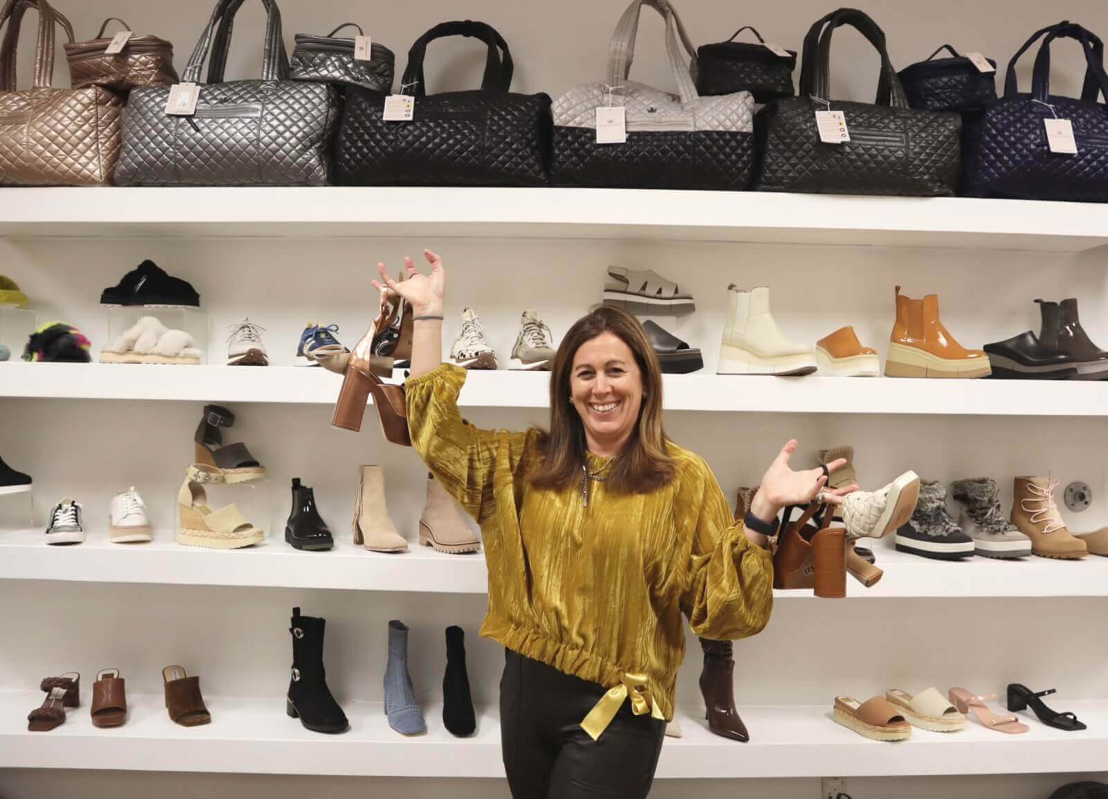 Photo of Moe Roebuck in front of shoe display at her store, Shoefly