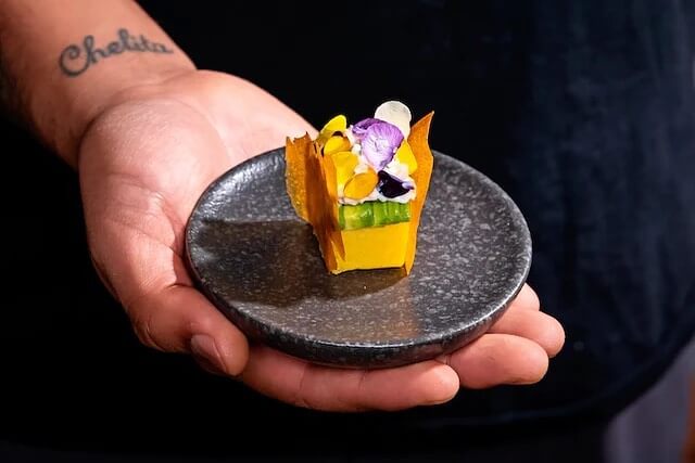 Person holding a plate of causa rellena.