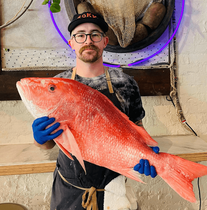 Man holding large red snapper fish.