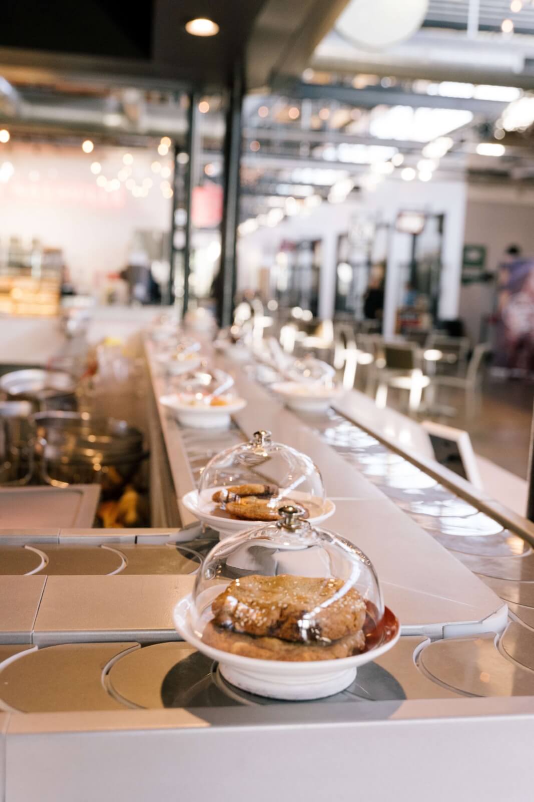 Charcuteries and desserts on a conveyor belt.